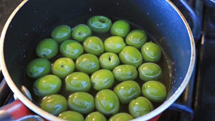 Olives floating gently in a pot of water