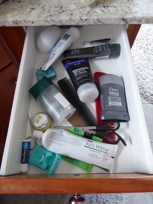 A before photo of a reviewer's toiletries cluttered and messily stored in a drawer.