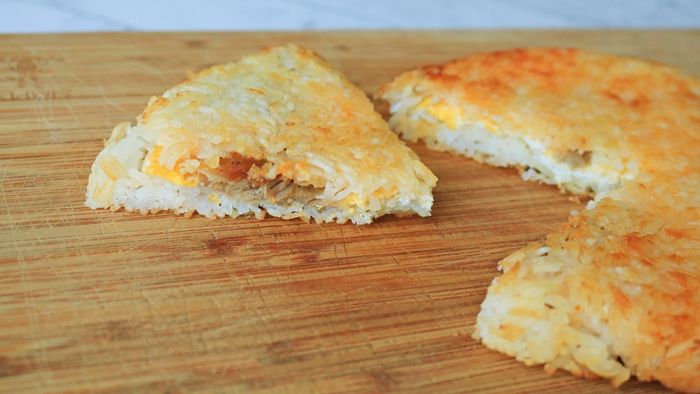 A crispy fried rice cake resting on a cutting board.