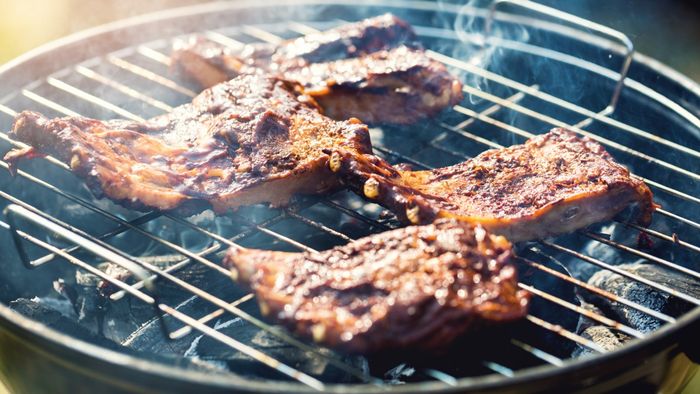 Grilling steaks on a charcoal grill.