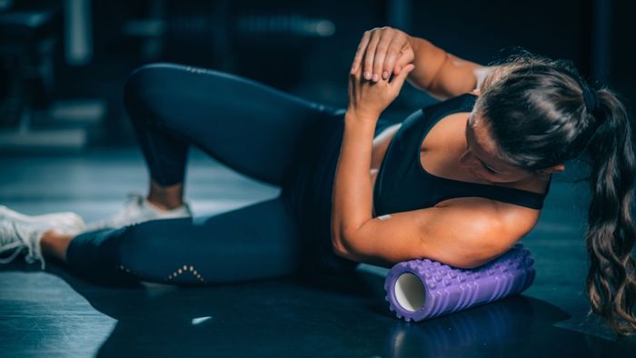 individual utilizing a purple foam roller