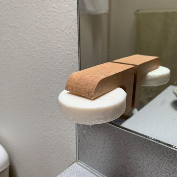 The magnetic soap holder with a bar of white soap attached.
