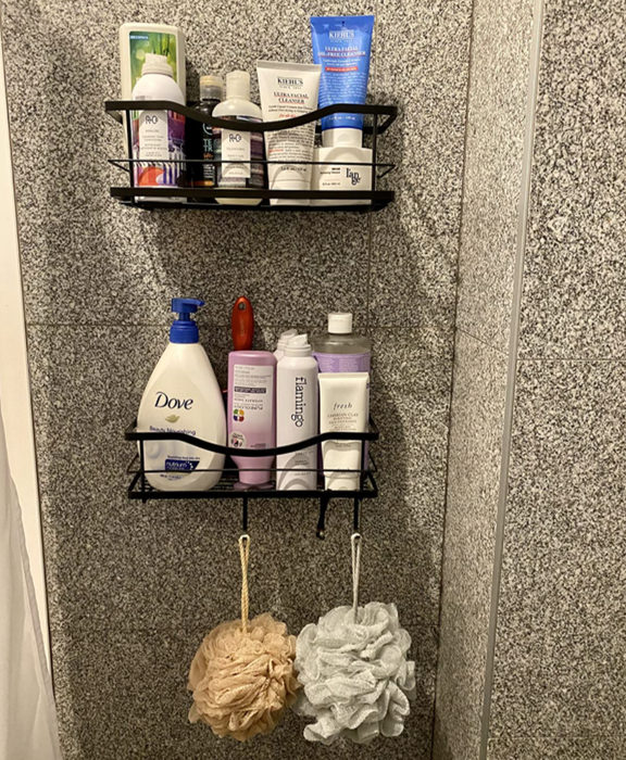 Reviewer photo showing black shelves attached to a shower wall, filled with various products.