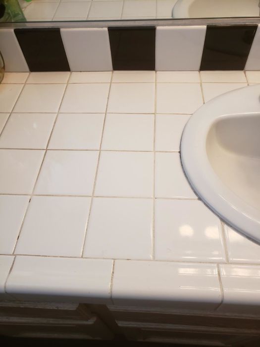 a tile counter with grout that has yellowed and stained over time
