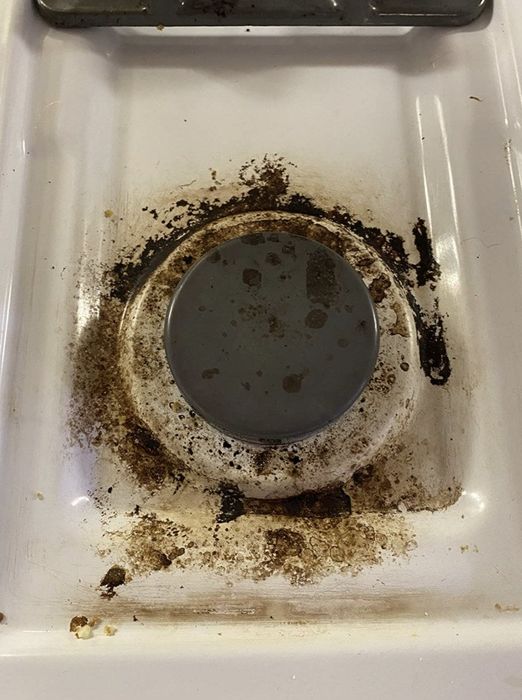 A photo from a reviewer showing their gas burner, covered in burnt food and greasy residues