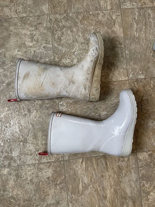 A reviewer's rubber boots, one stained with dirt and the other spotless