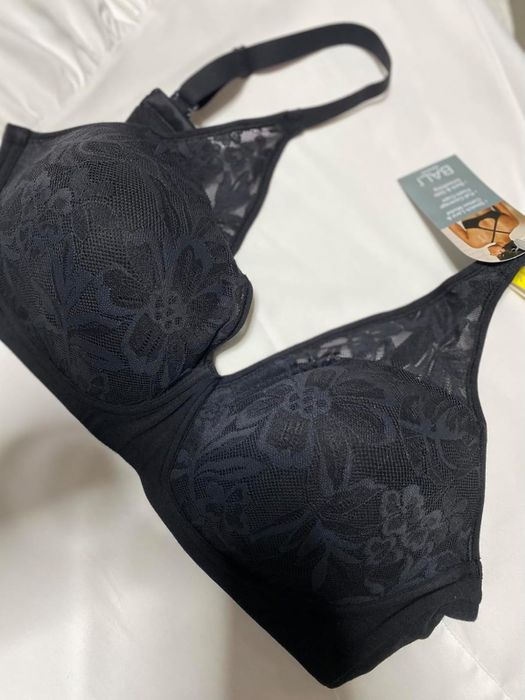 A black lace bra adorned with floral patterns, featuring a tag displaying product details.