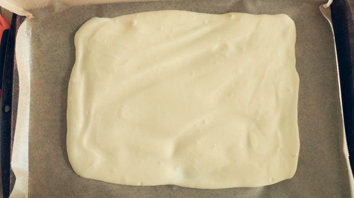 The batter is spread out across a sheet tray, ready for the next steps.