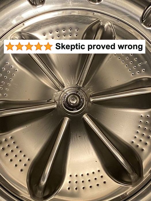 A picture from the reviewer showing their spotless washing machine with a five-star caption reading, 