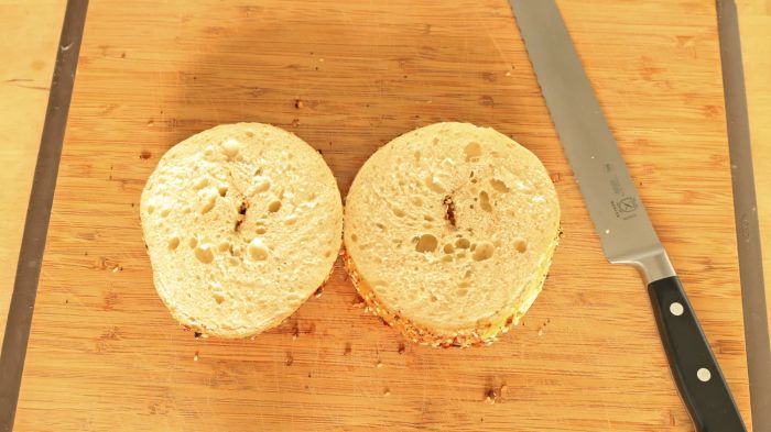 Two bagel halves resting on a cutting board.