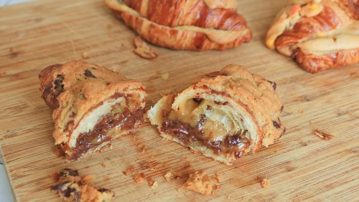 Croissant filled with cookie dough, sliced on a cutting board