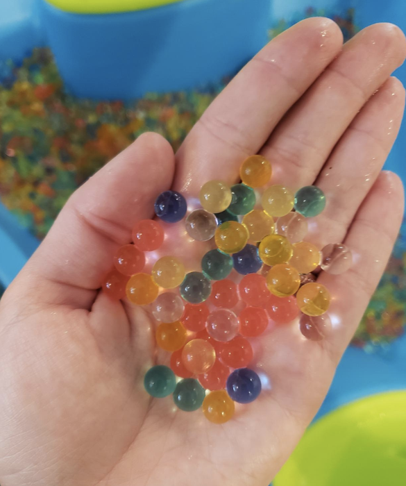 A reviewer holding the expanded water beads in their hand.
