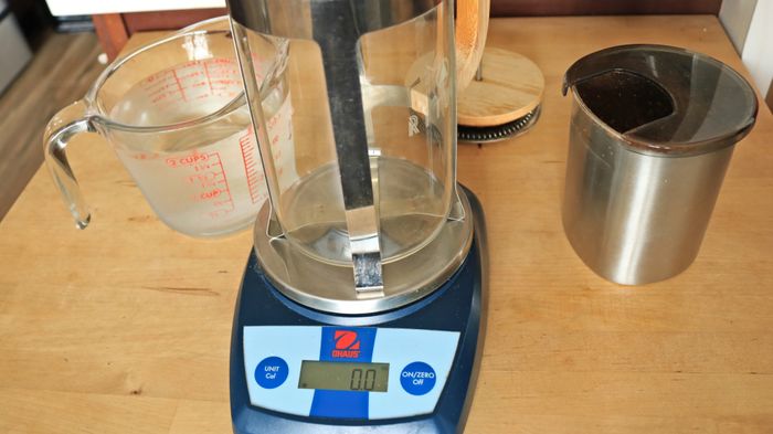 A French press placed on a kitchen scale.