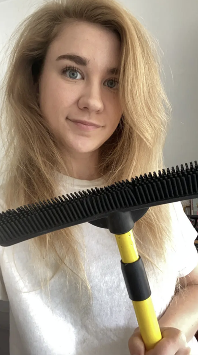 A Mytour editor is holding a broom with black silicone bristles
