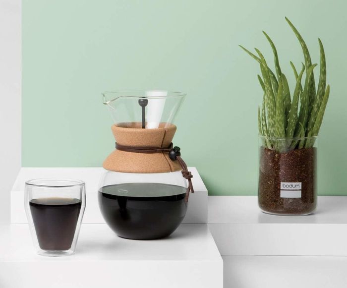 A glass pour-over coffee maker with a cork holder.
