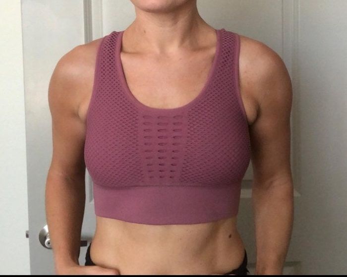 A reviewer wearing the bra in a soft pink shade