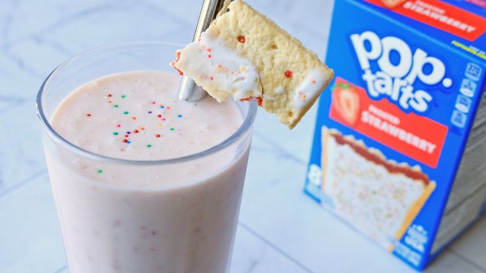 A milkshake placed next to a box of strawberry Pop-Tarts.