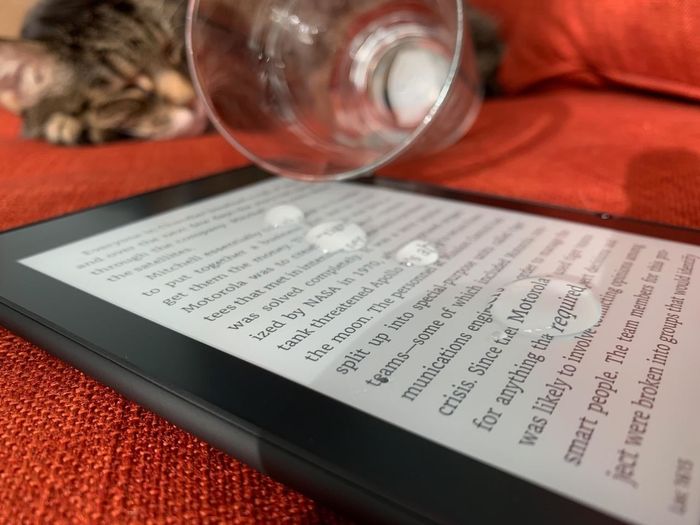 A reviewer image showing the Kindle screen with water spilled on it, proving its waterproof durability.