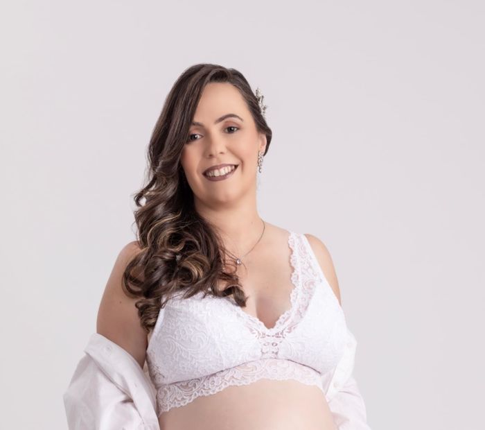 A reviewer models the white bralette.