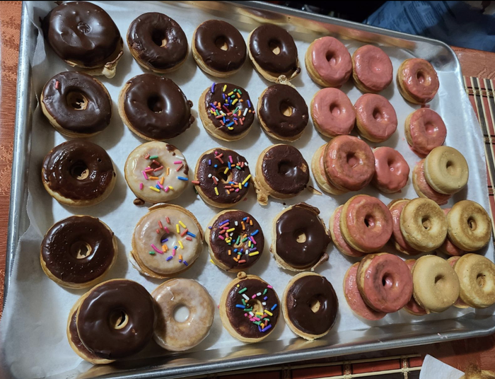 A reviewer's image of a tray of donuts topped with a variety of frostings.