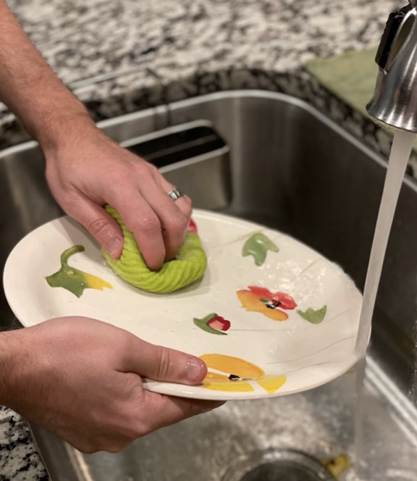 A reviewer wiping a plate with the sponge cloth