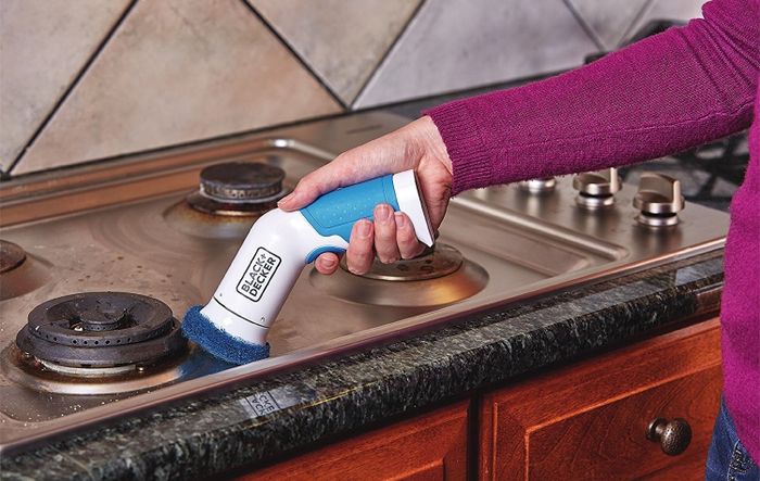 A model is using the scrubber on the stovetop