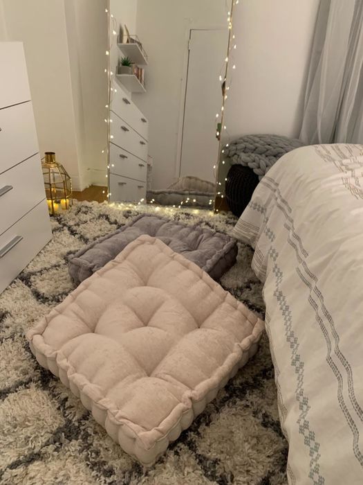 A pillow placed on a soft, fluffy white carpet, adding a touch of comfort.
