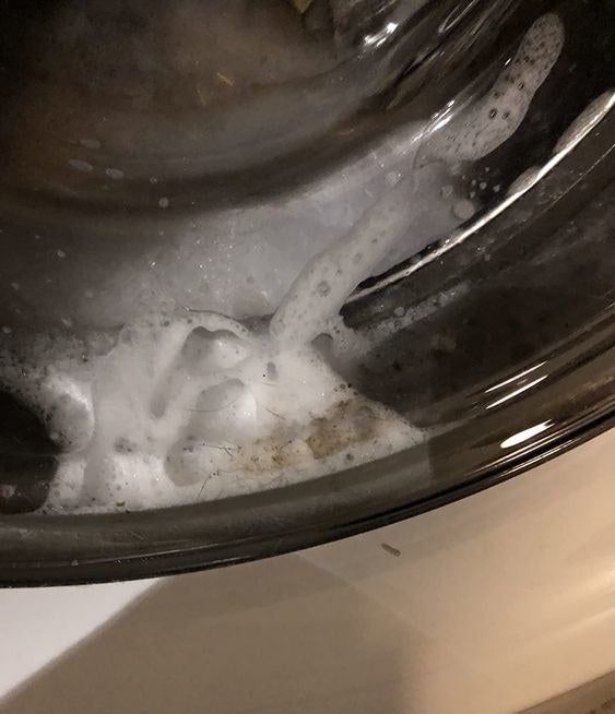 A reviewer’s picture of their washing machine’s dirty soap water during the cleaning cycle