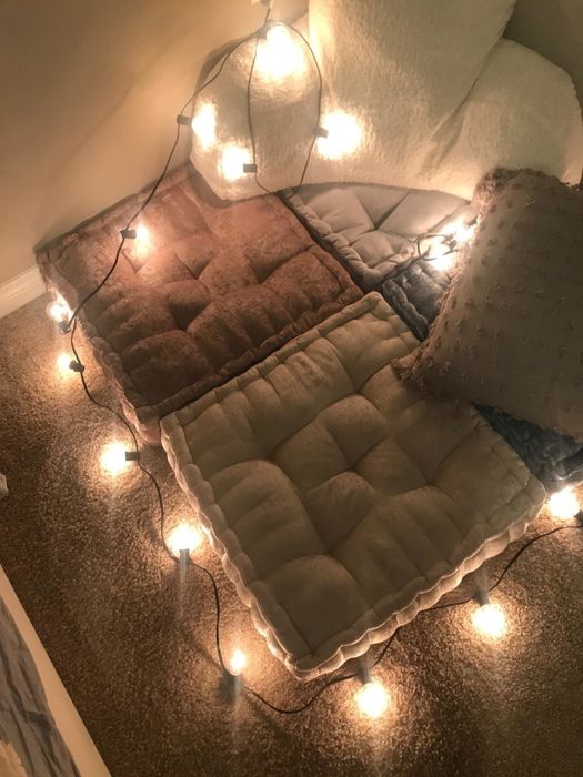 Cushions surrounded by string lights, creating a cozy atmosphere.