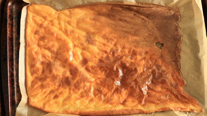 The egg white batter cooked unevenly on a sheet tray, with some areas overcooked.