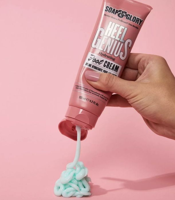 a person dispensing the cream from its pink tube