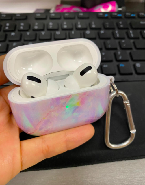 hand holding a marble-patterned AirPods case