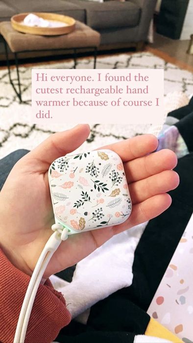 A reviewer holding the hand warmer with a floral design