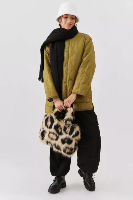 Model carrying a leopard print fuzzy tote