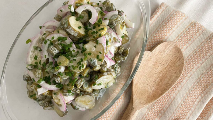 A bowl of pickle salad sits on a table.