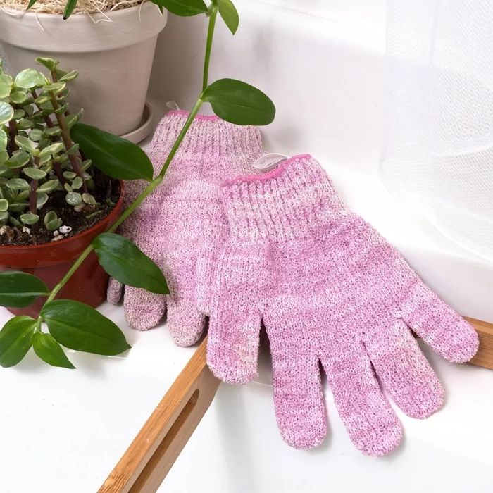 A pair of pink knitted exfoliating gloves.