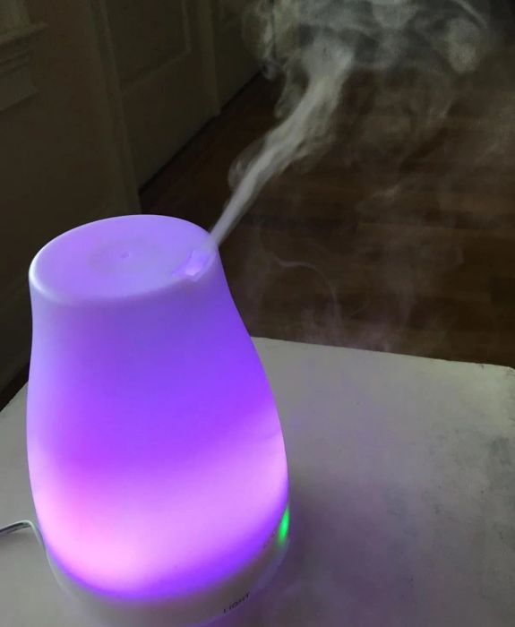 The diffuser glowing in purple while releasing mist
