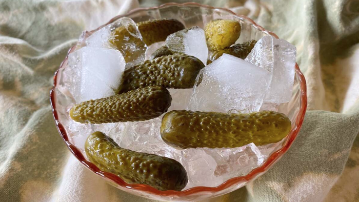 A bowl of ice, topped with pickles.