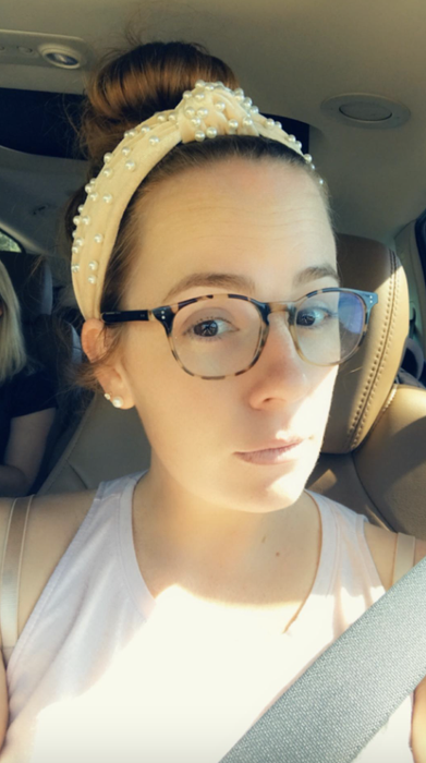 The reviewer wearing the velvet headband, showcasing its faux pearl embellishments
