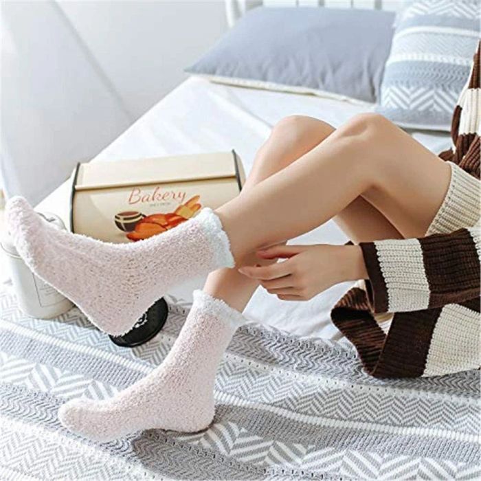 Model showing off fuzzy pink socks with a white trim