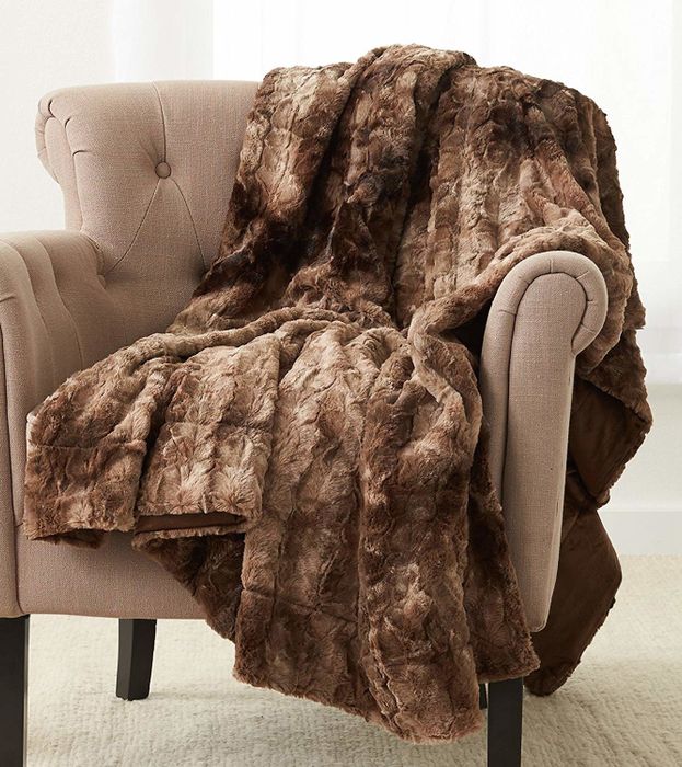 A faux fur blanket draped over the back of a chair