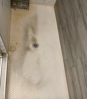 A customer's review image showing half of their shower floor cleaned