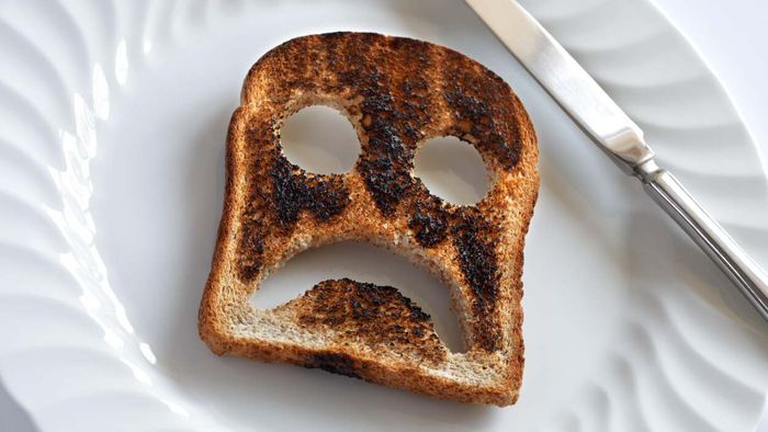 A burnt piece of toast shows a sad, scorched face.