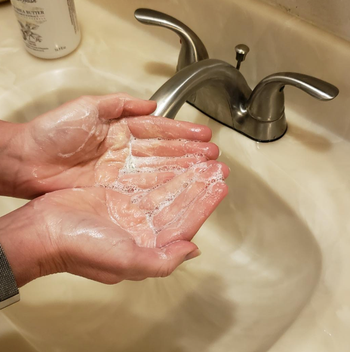 A reviewer with soapy hands after the paper dissolved in warm water