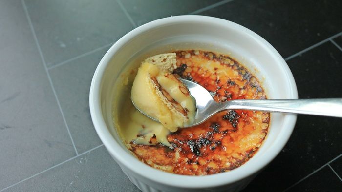 A spoonful of crème brûlée being scooped up.