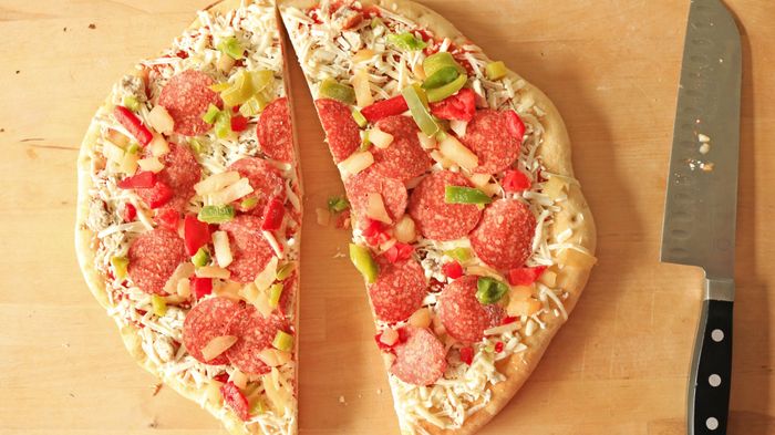 A frozen pizza cut neatly in half, showing off the slices.