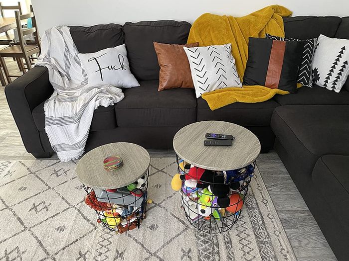 A reviewer's two nesting tables, filled with toys, placed by their couch.