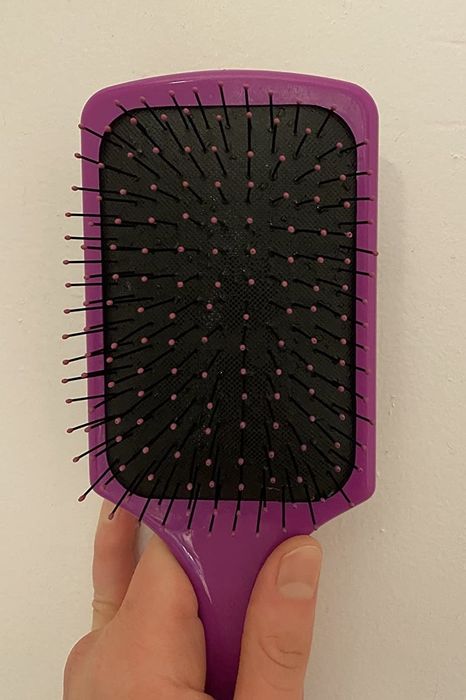 A photo from the reviewer showcasing the same brush now completely cleared of hair.