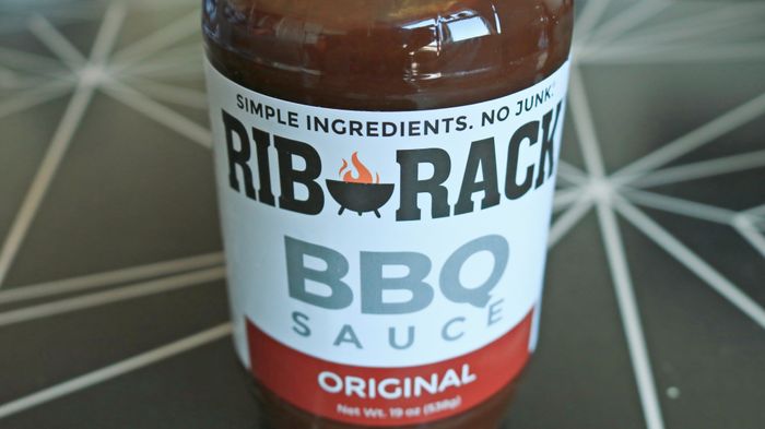 A close-up of a Rib Rack barbecue sauce bottle
