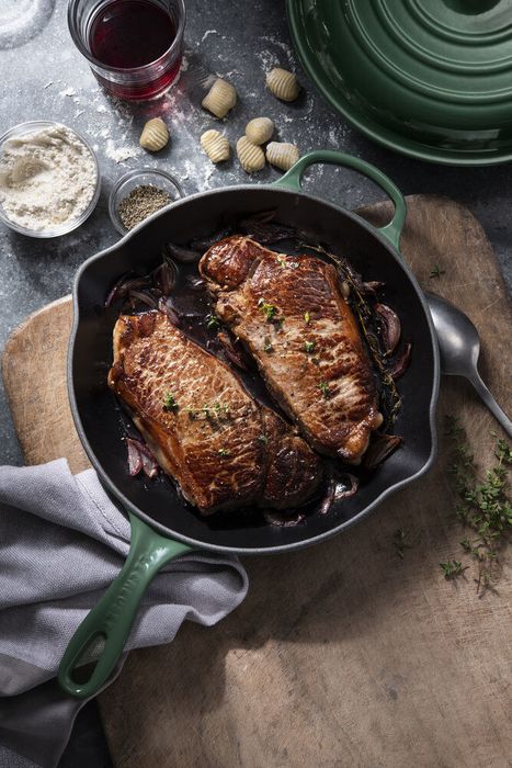 A piece of meat sizzling away in the cast-iron skillet, showcasing its cooking power.